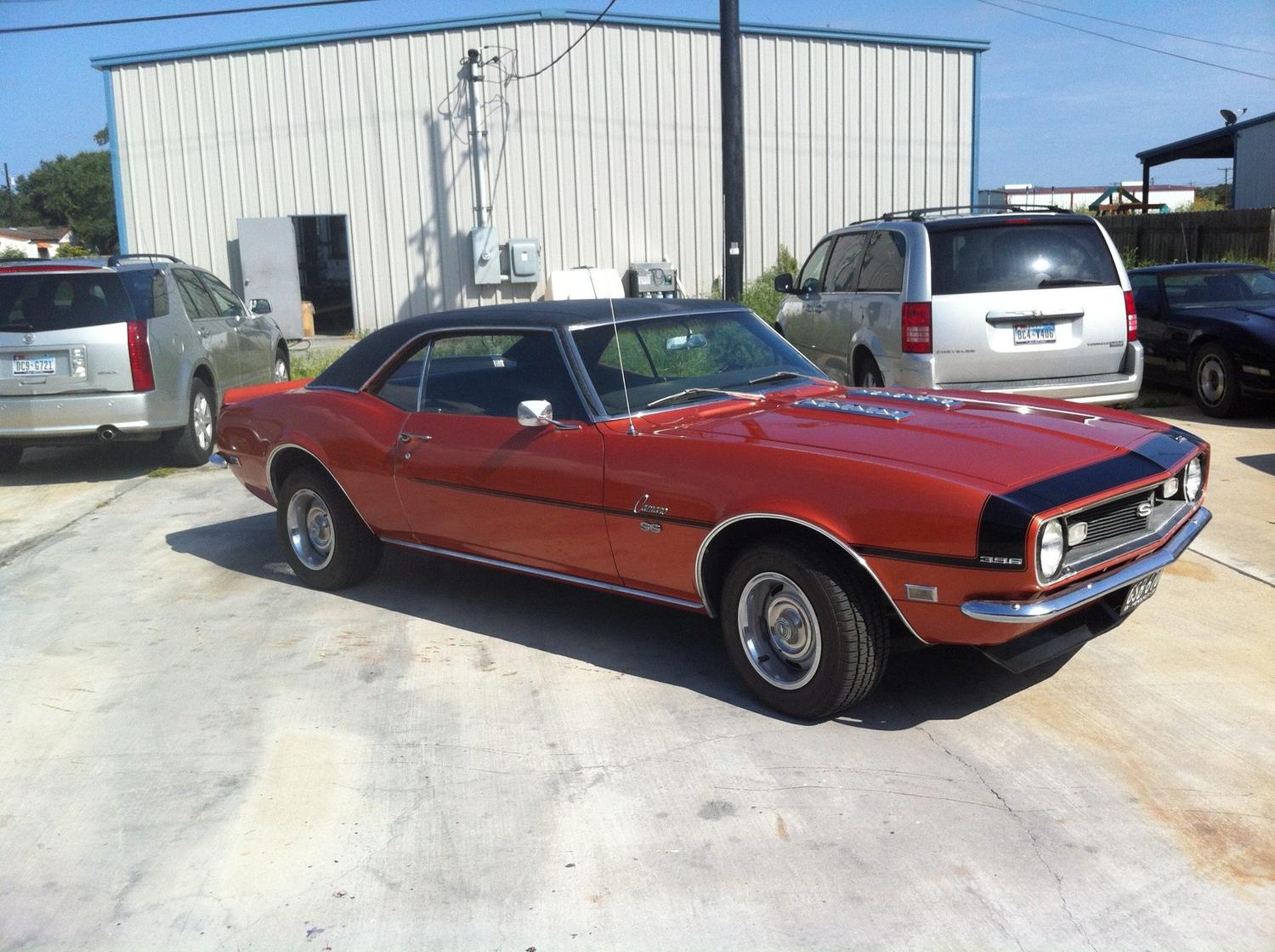 Restored Camaro SS 396 in orange with a black vinyl top