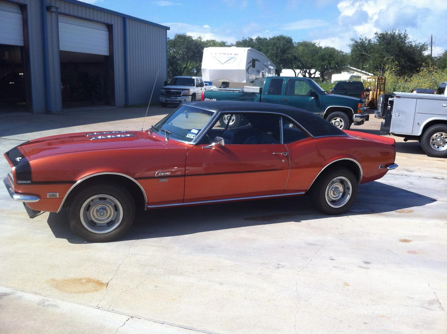 Restored orange Camaro SS 396 parked outside the shop