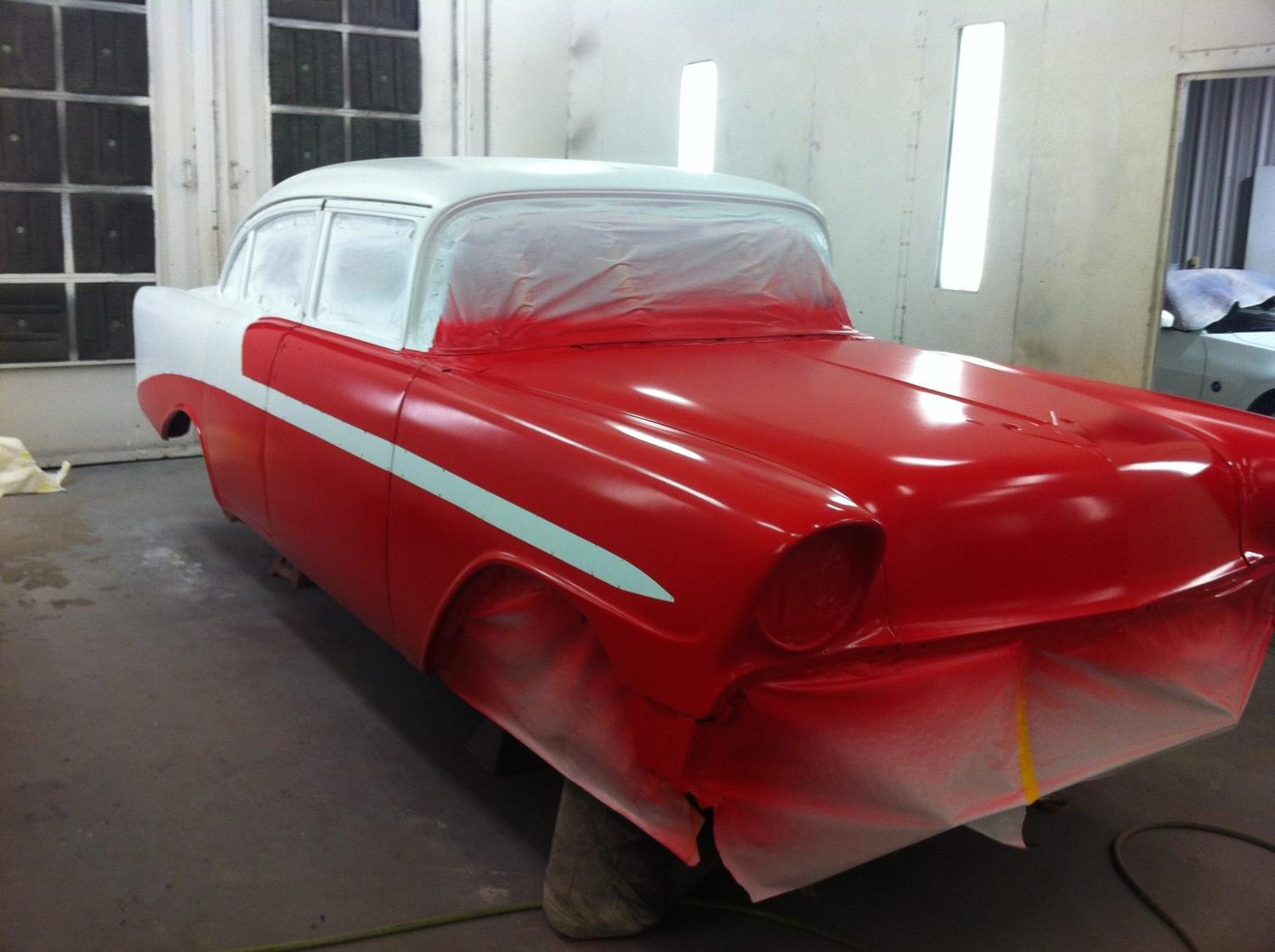 A 1956 Chevrolet masked and mid-repaint inside the paint booth